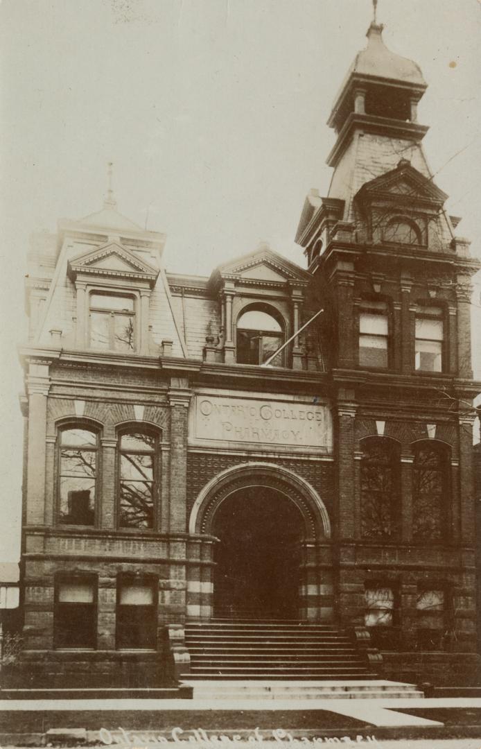 Black and white photograph of a large, Victorian, collegiate building with a turret.