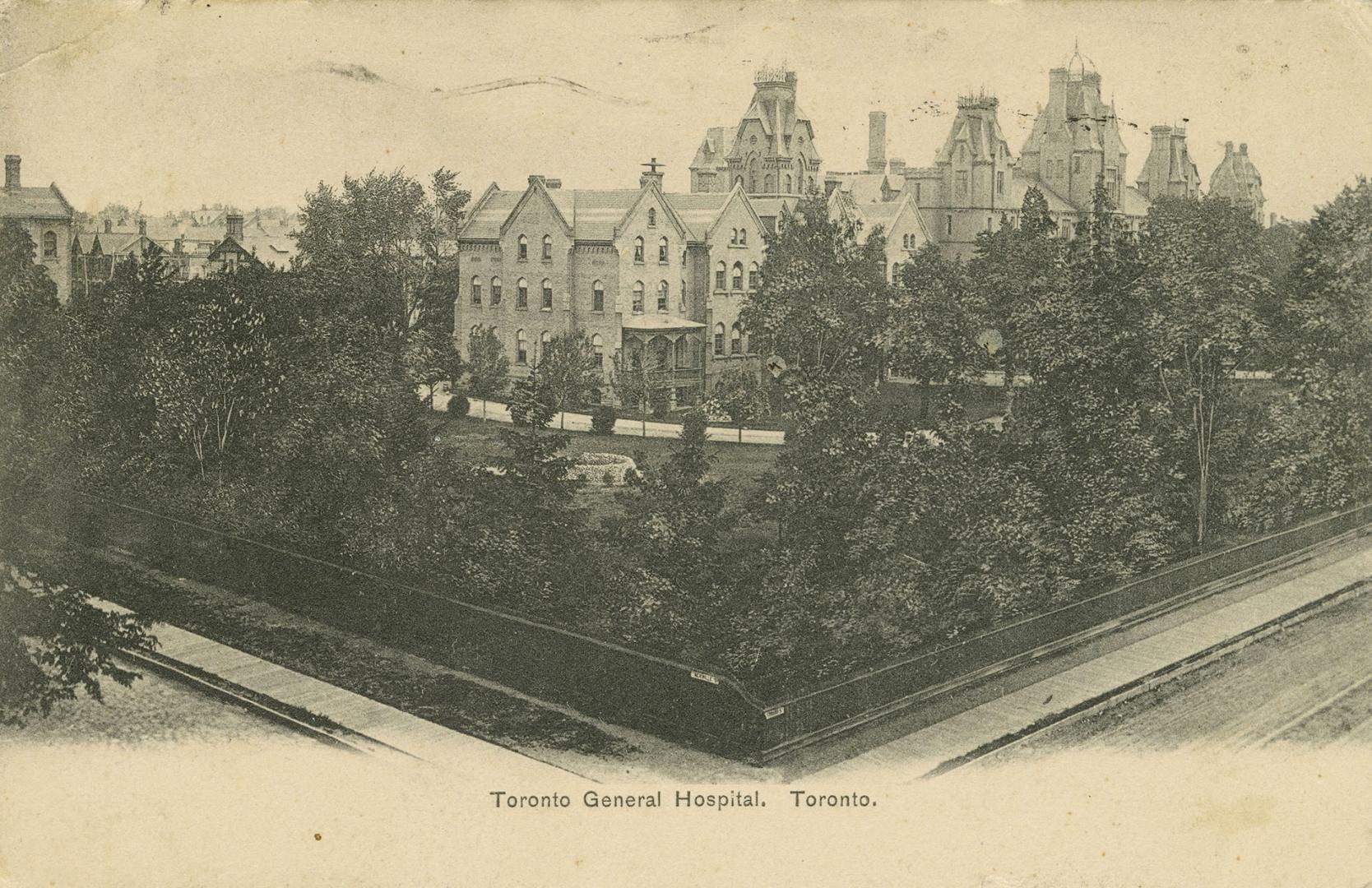 Black and white photograph of a large hospital complex surrounded by trees.