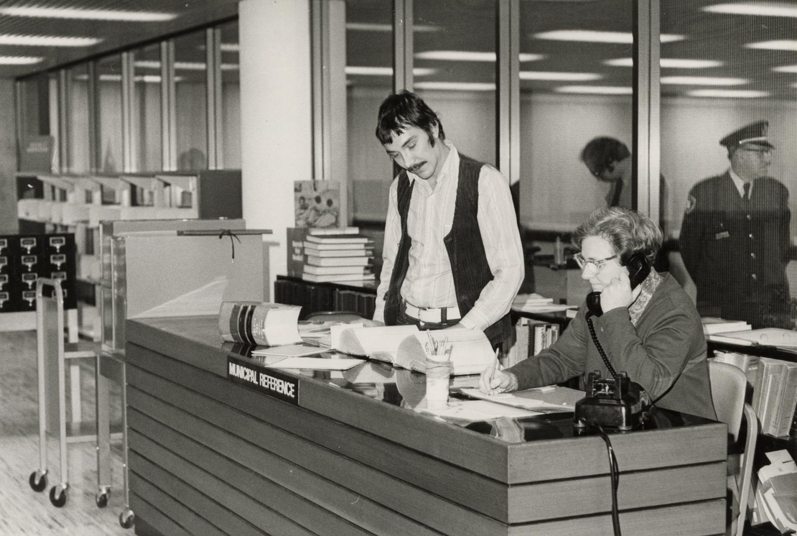 Picture of librarians at a reference desk. 