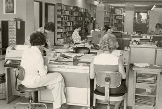 Picture of library staff working in an office seated at desks. 