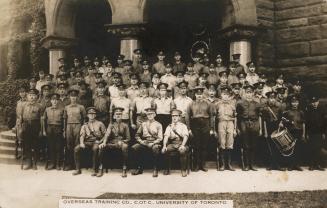 Black and white photograph of soldiers in uniform standing in lines in front of a Victorian bui ...