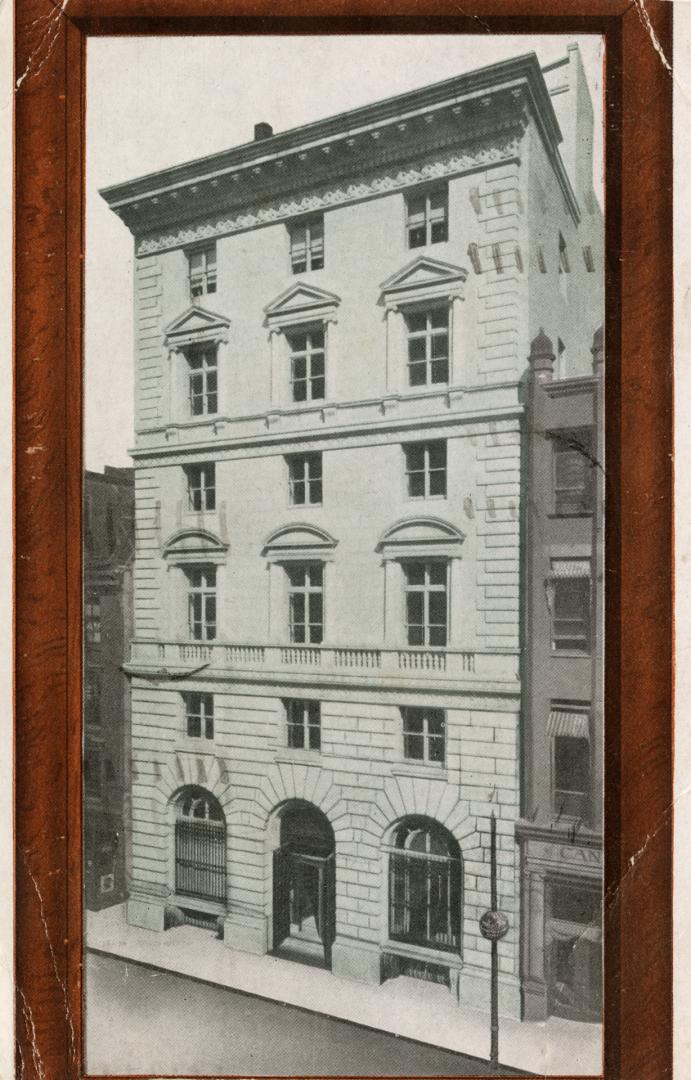 Black and white photo postcard with an auburn-brown frame, depicting the exterior view of a bui ...