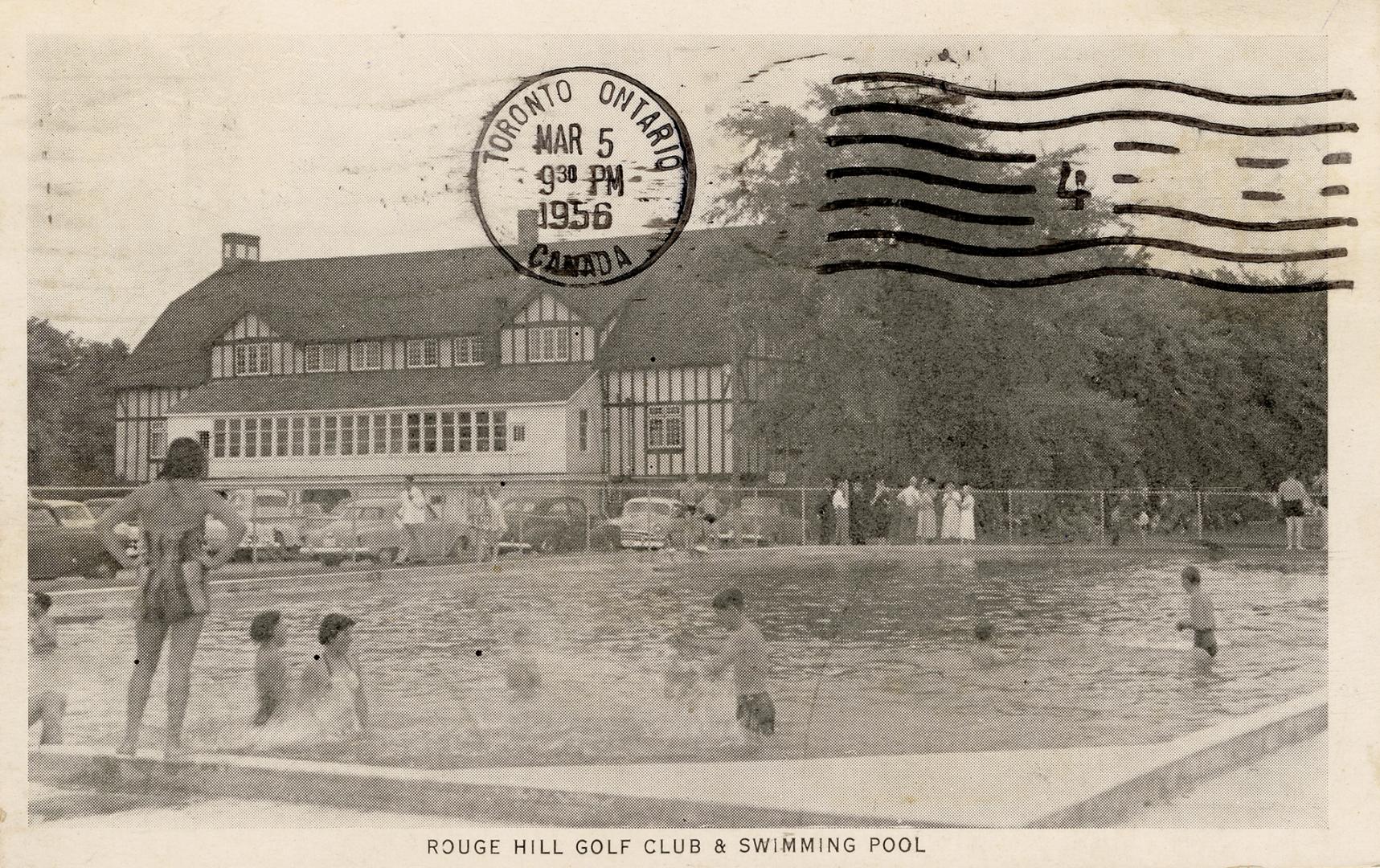 Black and white photograph of people in a swimming pool in front of a mock tudor building.