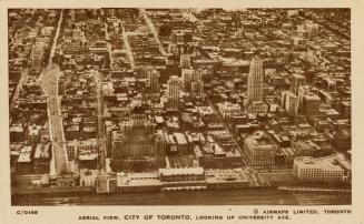 Sepia-toned photo postcard depicting an aerial view from the train tracks looking north. The ca ...