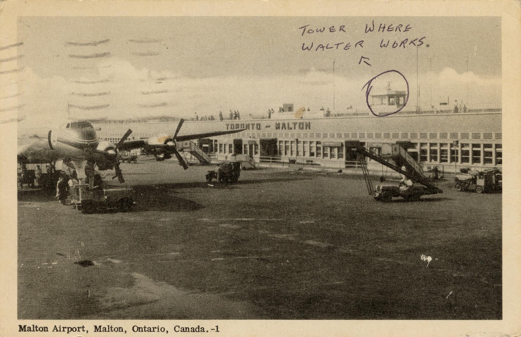 Black and white photo postcard depicting an airplane in front of a flat, wide building with an  ...