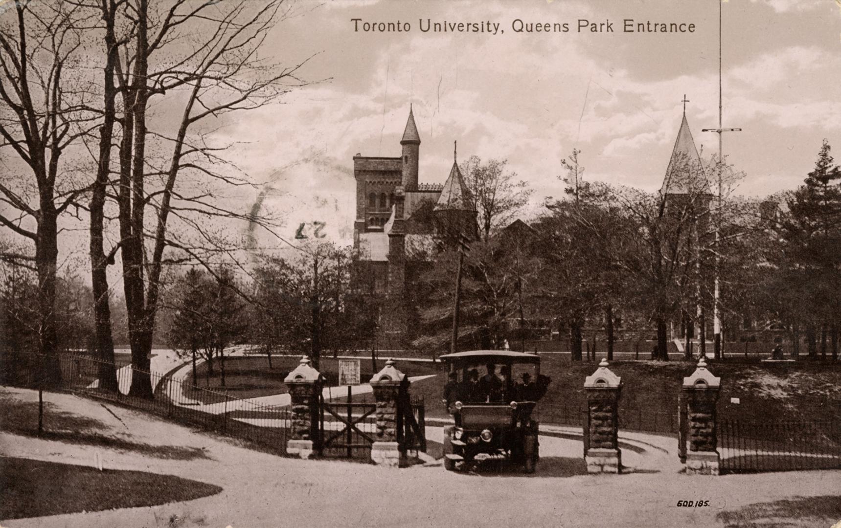 Black and white photograph of people in a horseless carriage waiting at a gate with four pillar ...