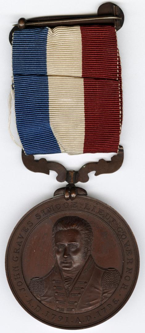 Copper medal with red, white, and blue ribbon and clasp.Decorative hanger at 12 o’clock.(revers ...