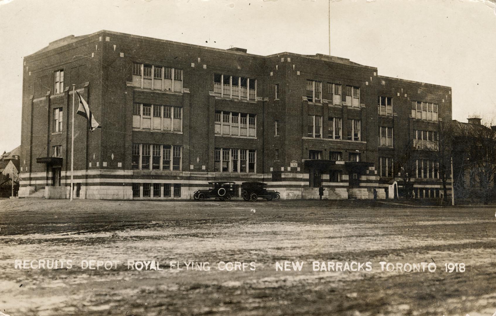 Black and white photo postcard depicting the exterior of a large three-story building. The capt ...