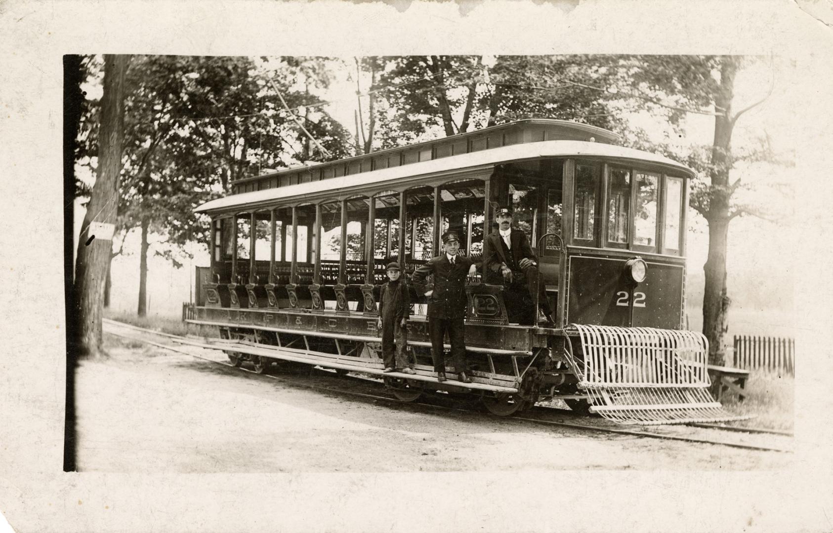 Black and white photo postcard of a streetcar with open sides, a front grill, the number 22 on  ...