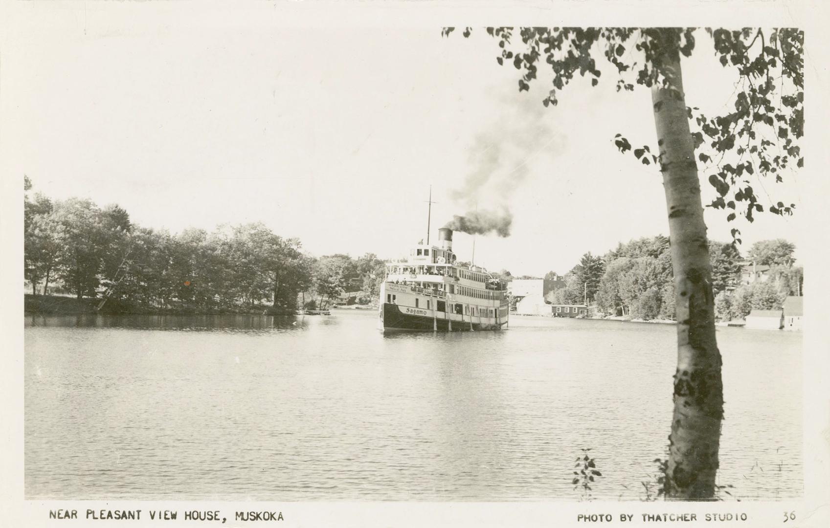 Black and white photograph of a large steamship sailing up a lake.