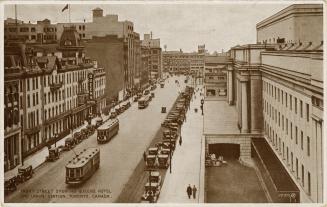 Sepia tone photograph of streetcars and other traffic on a busy city street with large building ...