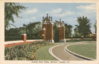 Colorized photograph of a large brick gate in the middle of an urban park.