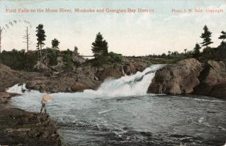 Colorized photograph of a man fishing from a rock in front of a waterfall.