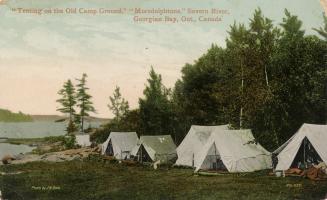 Colorized photograph of six tents pitched on the side of a river.