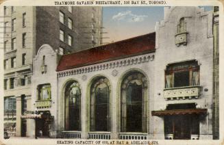 Colour photo postcard depicting the exterior frontage of a two-story building with three large  ...