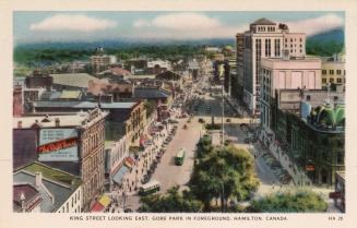 Colorized photograph of a busy city street taken from the air.