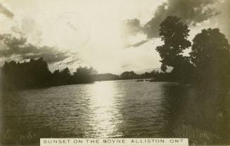Black and white photograph of a wide body of water surrounded by trees.