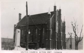 Black and white photograph of small country church with snow around it.