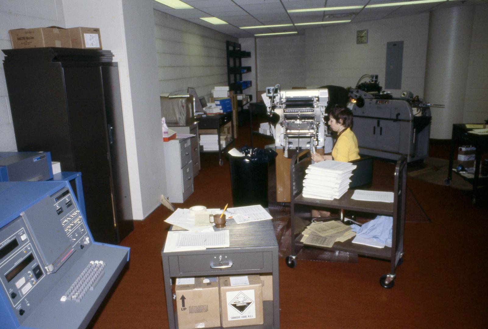 Picture of library work room with special equipment and person working at machine. 