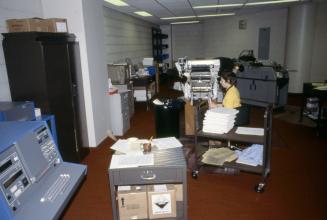 Picture of library work room with special equipment and person working at machine. 