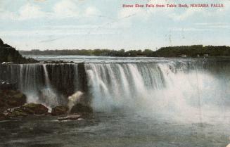 Colorized photograph of powerful waterfalls. A small boat is sailing underneath them.