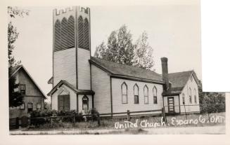Black and white photograph of small country church with a steeple.