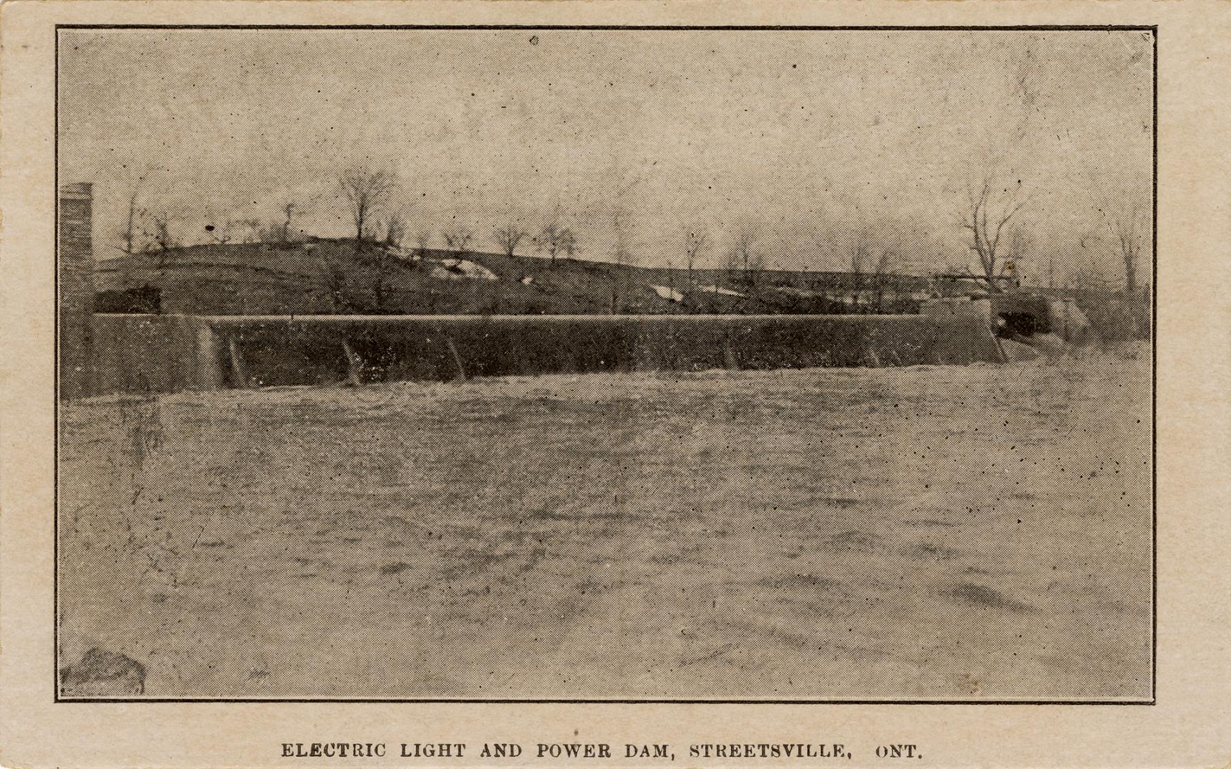 Black and white photograph of a dam across a river.