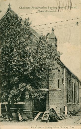Black and white photograph of a brick building under construction.