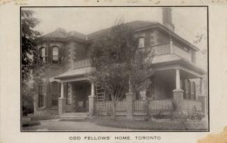 Black and white photograph of a two story house with shutters on the windows.