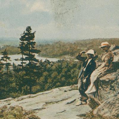 Man and woman shown in part of vintage postcard highlighting scenic nature view
